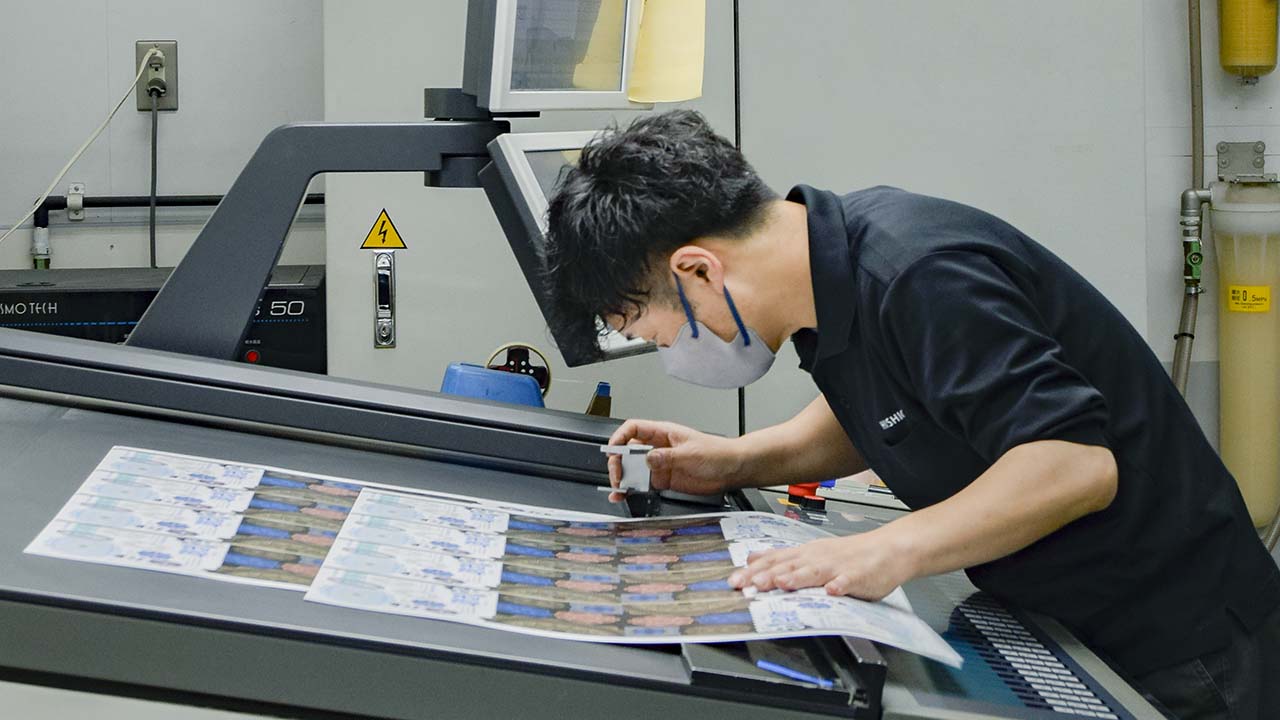 印刷会社 菱源の印刷課、印刷オペレーターによるオフセット印刷の確認